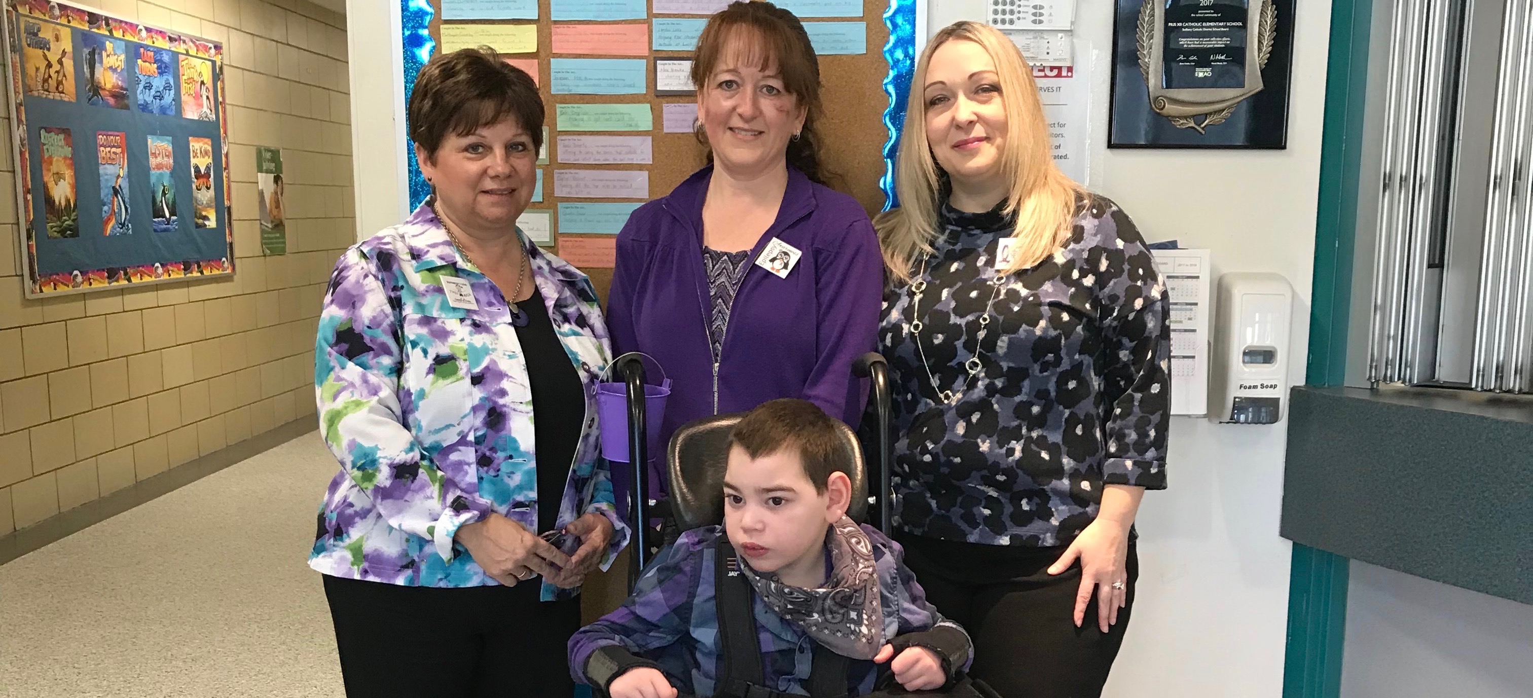 Three teachers at Pius XII School stand with a lifeskills student to promote epilepsy awareness.