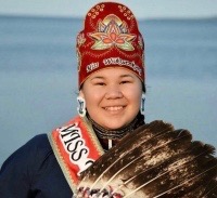 St. Charles College student Dana Lewis smiles in traditional Indigenous attire.