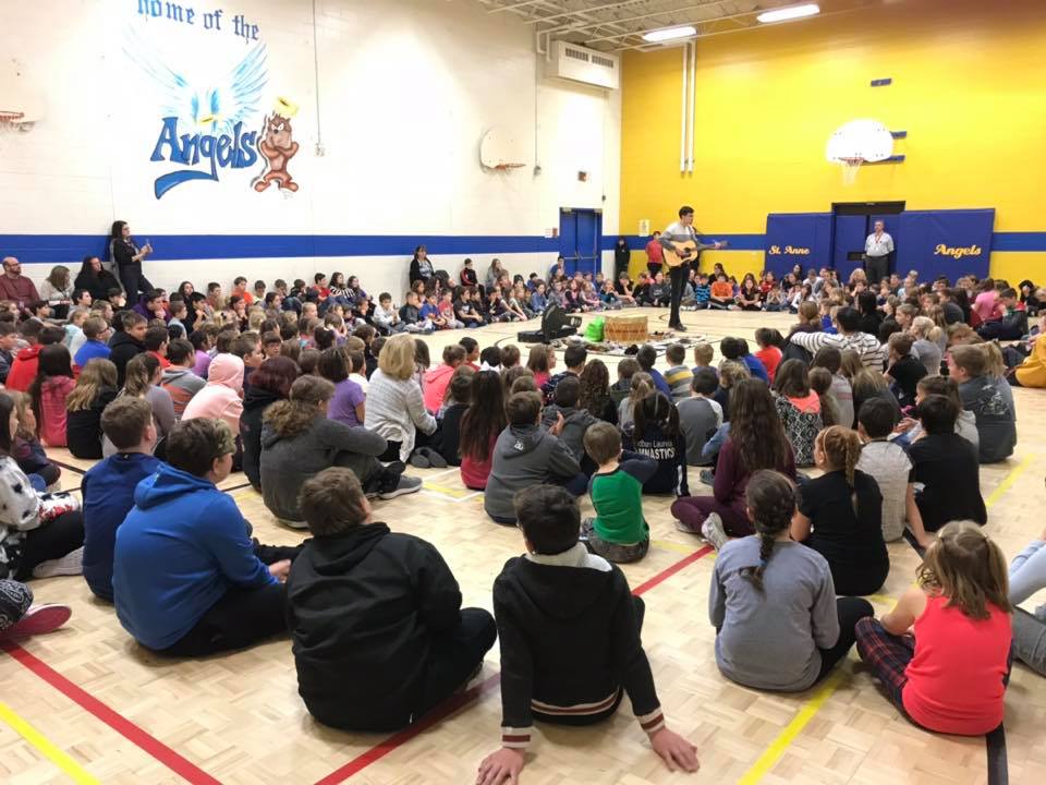 Students gather in a circle as tradiitonal Indigenous song is sung.