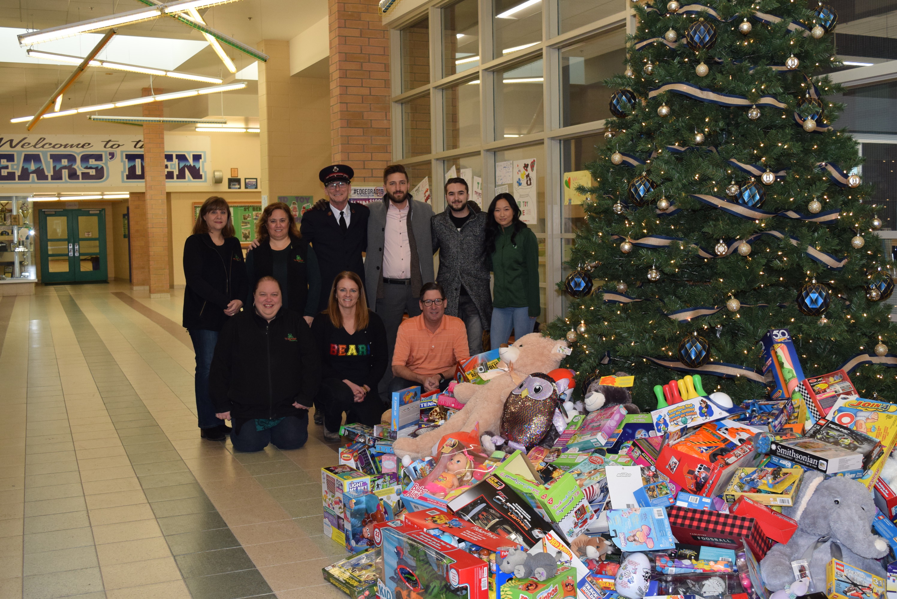 Staff, Students and TD Bank representatives stand proudly with a tree surrounded by toys which will be donated.