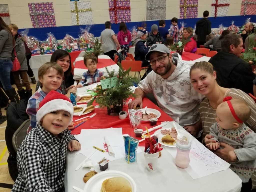 A happy family gathers to eat breakfast at Holy Trinity