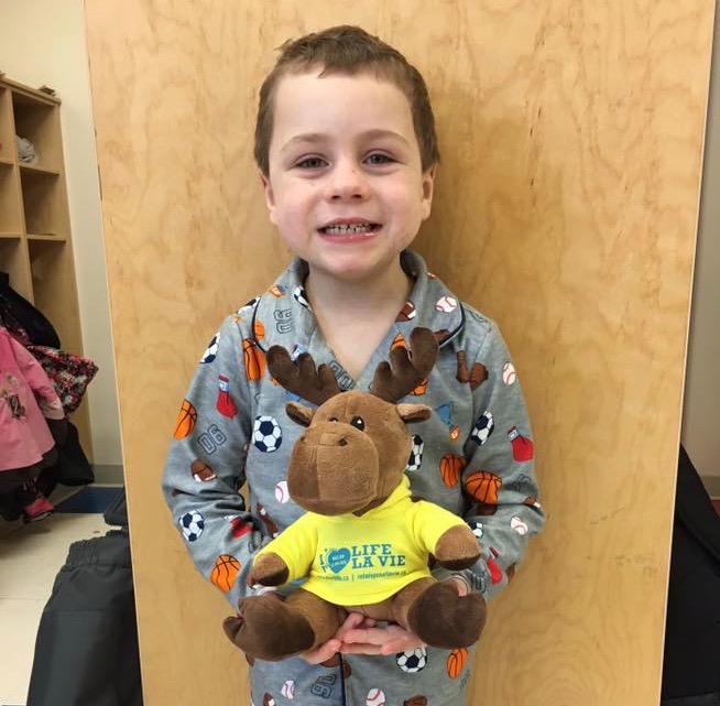 Student Nicky stands smiling with his pet moose