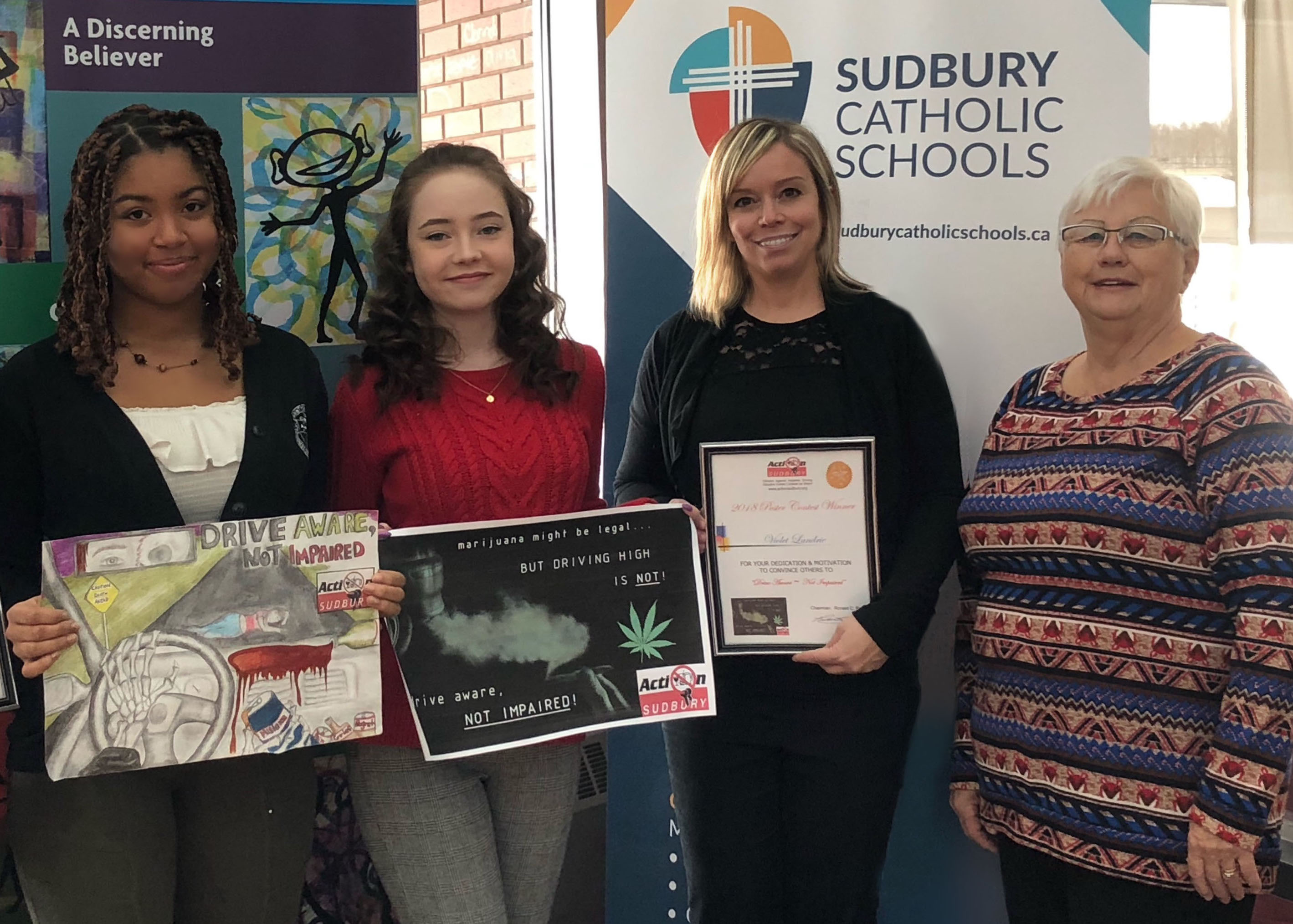 Students stand proudly with their winning posters.