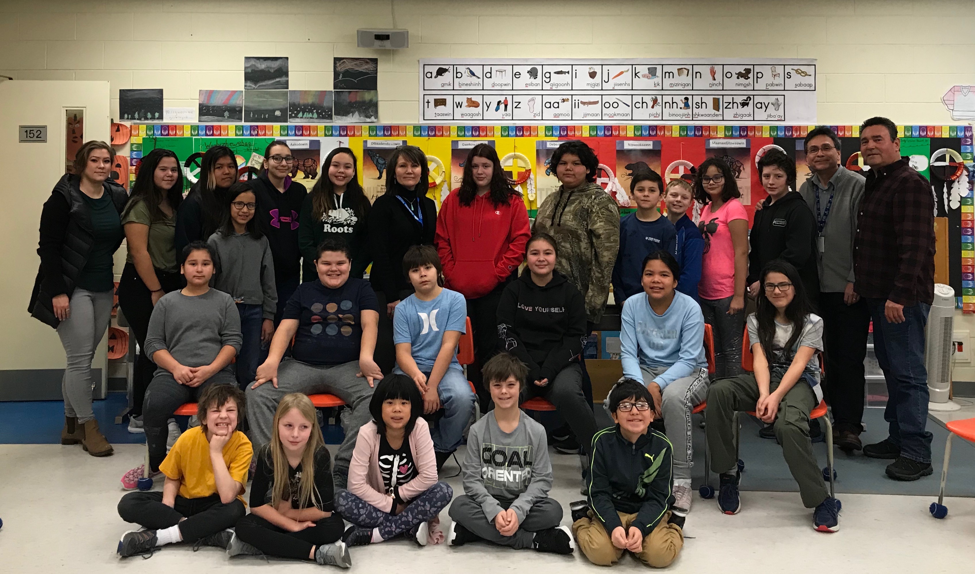 The Native Second Language class stands smiling alongside their teacher and Chief Valerie Richer.