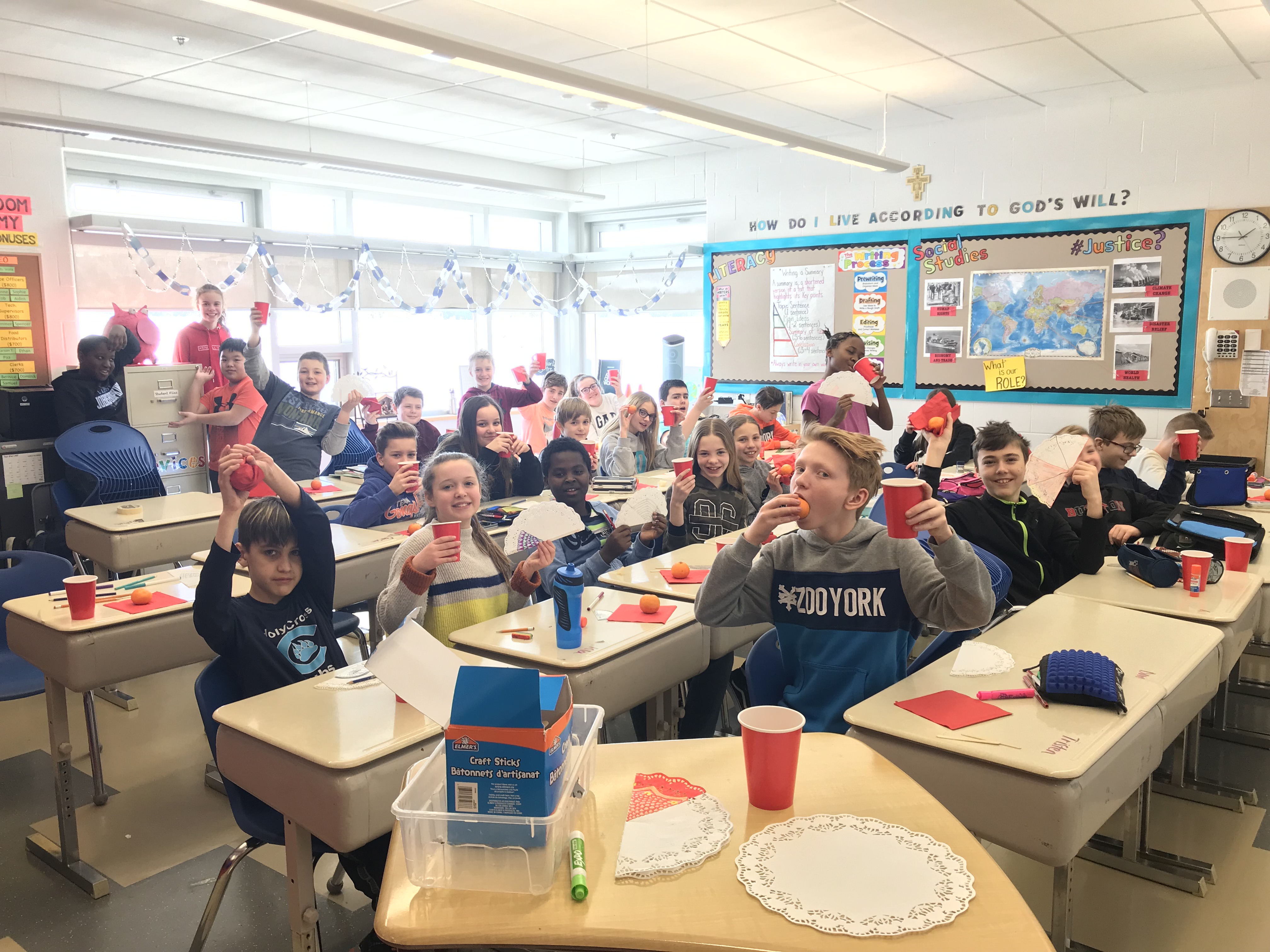 Grade 6 students at Holy Cross School raise their hands in celebration of Chinese New Year!