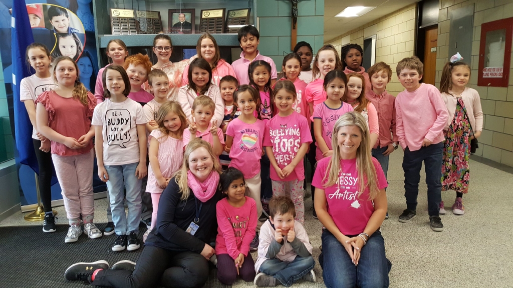 Pius XII Students stand together in their pink shirts.