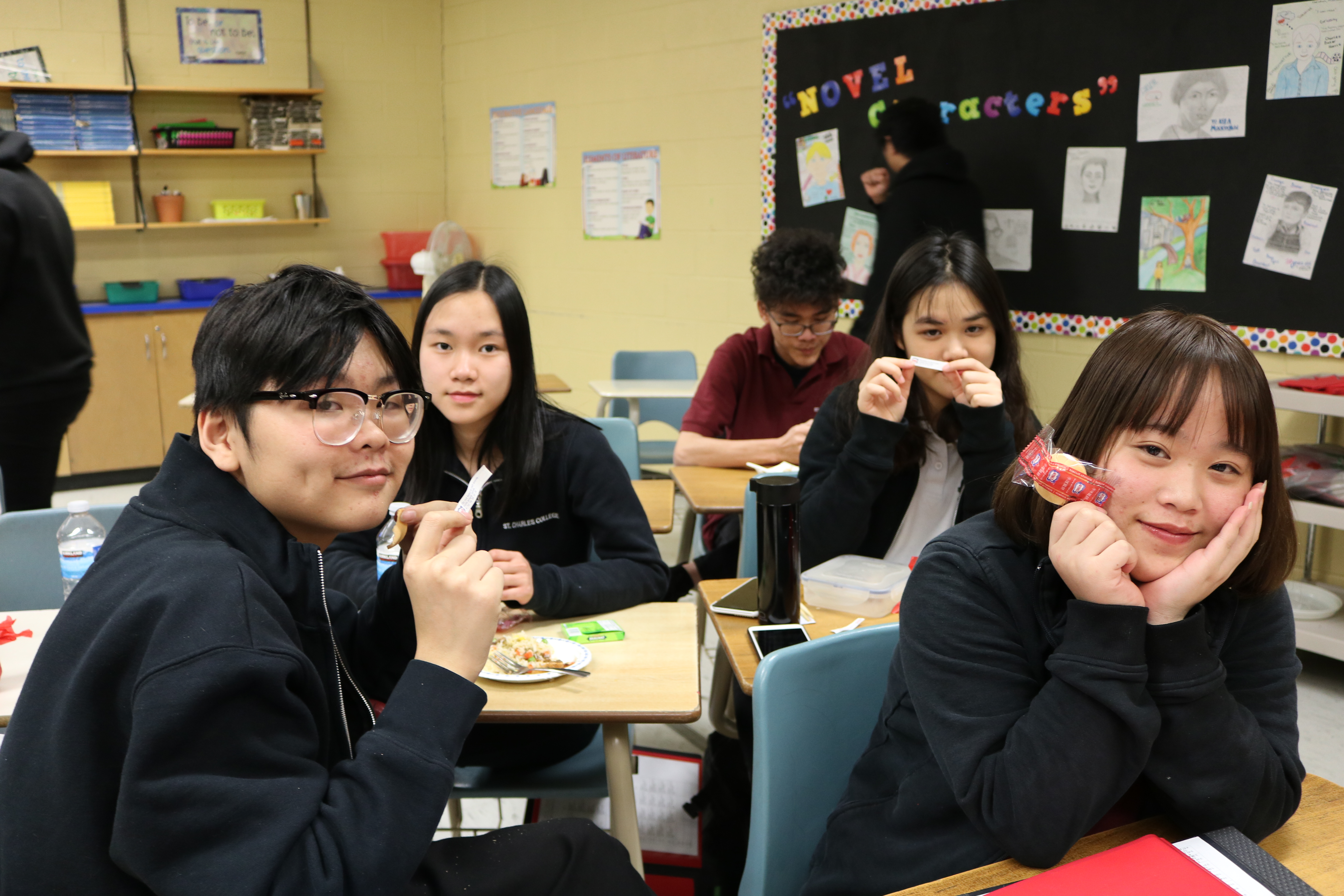 Chinese Students sit smiling as they feast on a traditional Chinese meal.