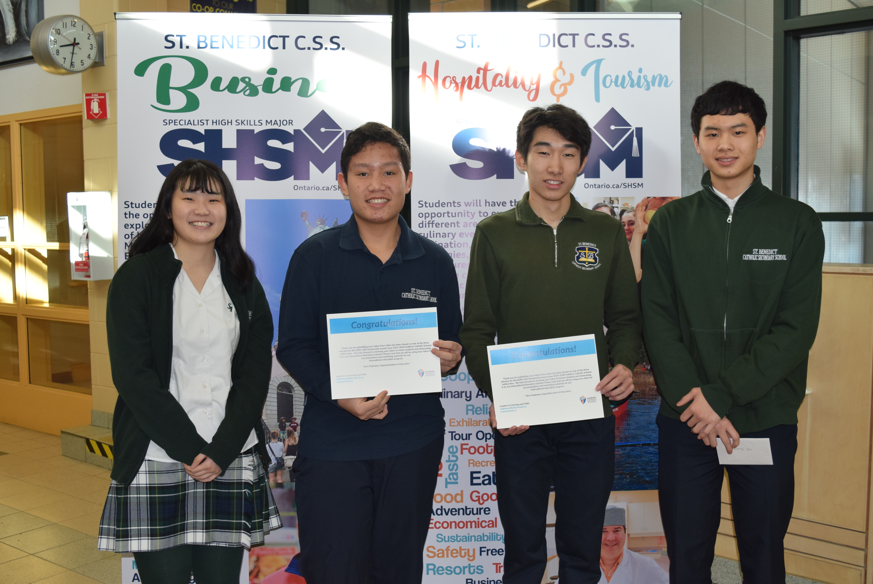 Scholarship winners stand smiling with their certificates.