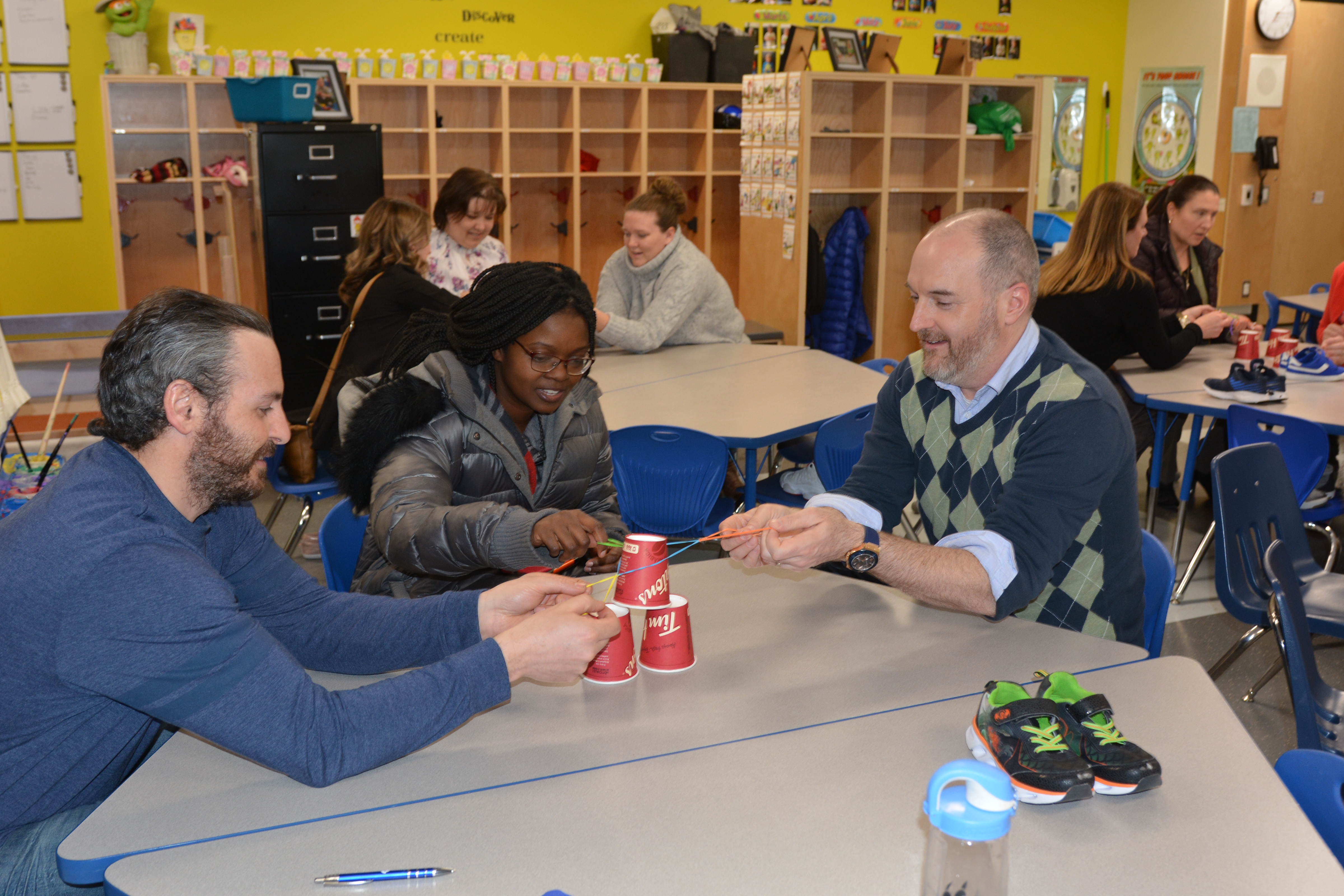 A group of parents engage in a team building activity.