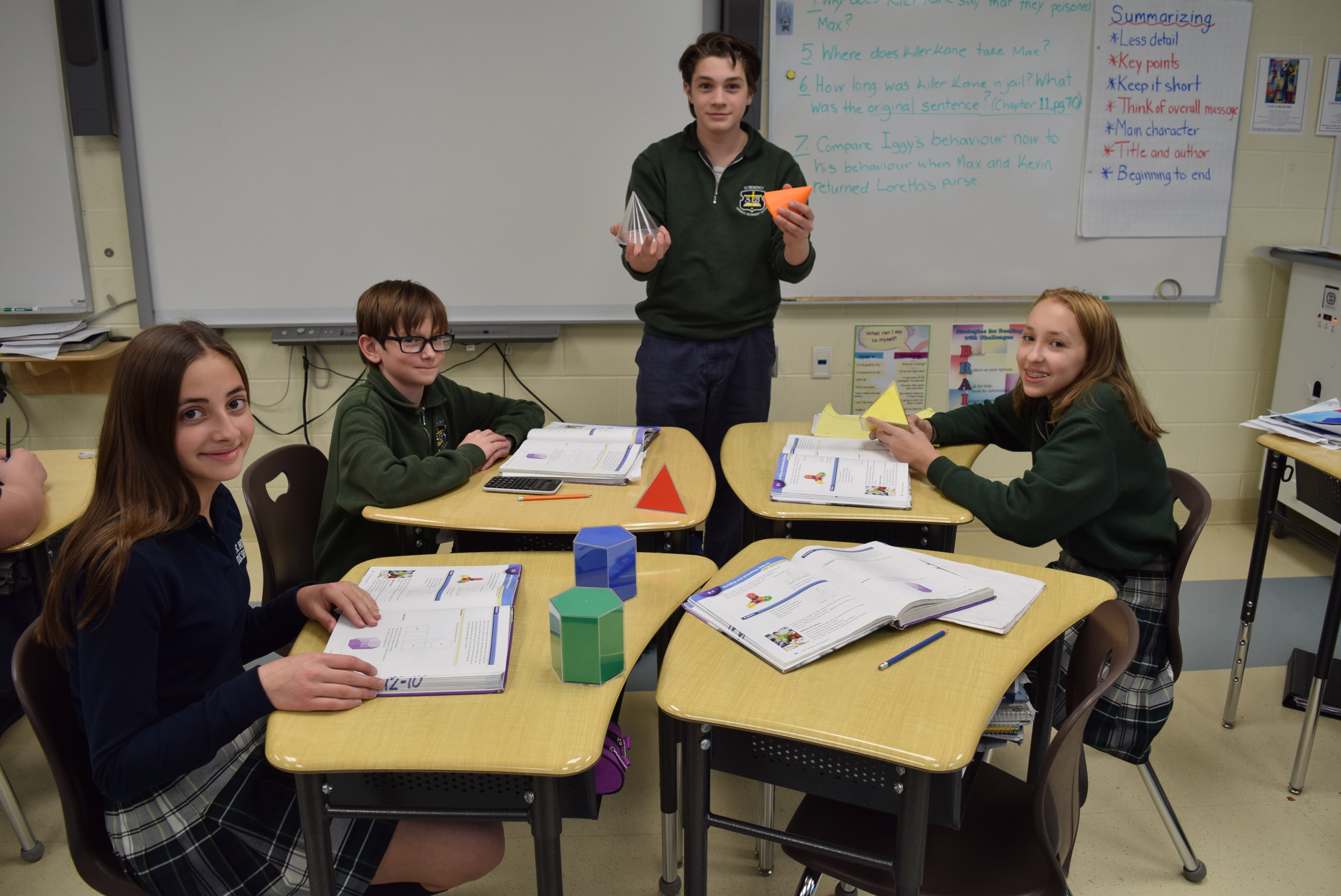 Two male students and two female students study geometrical shapes.