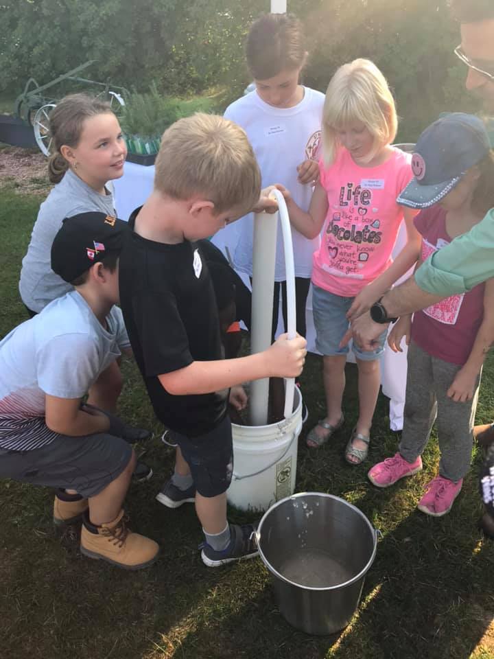 A group of students source water from a bucket.