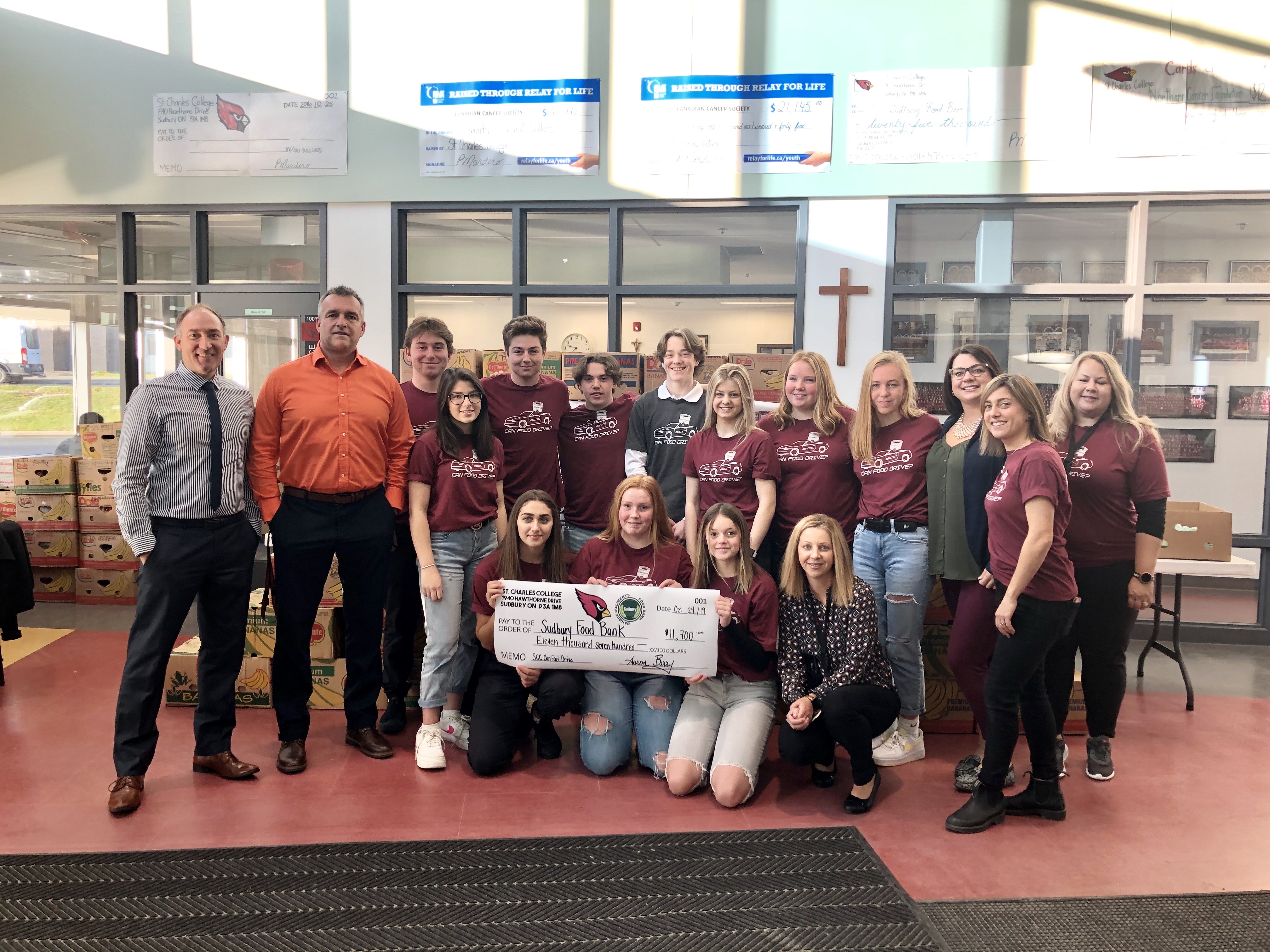 Staff and students gather together with a giant cheque for over $11,000