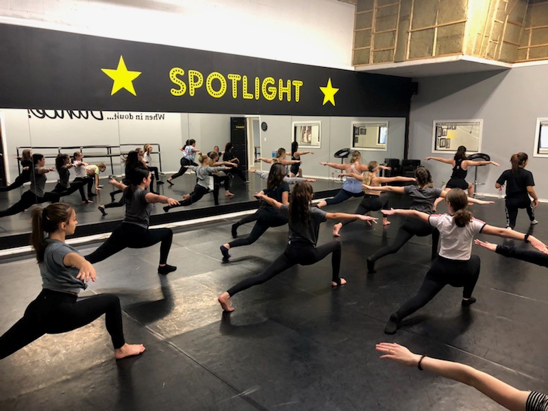 A group of students dance in a studio.