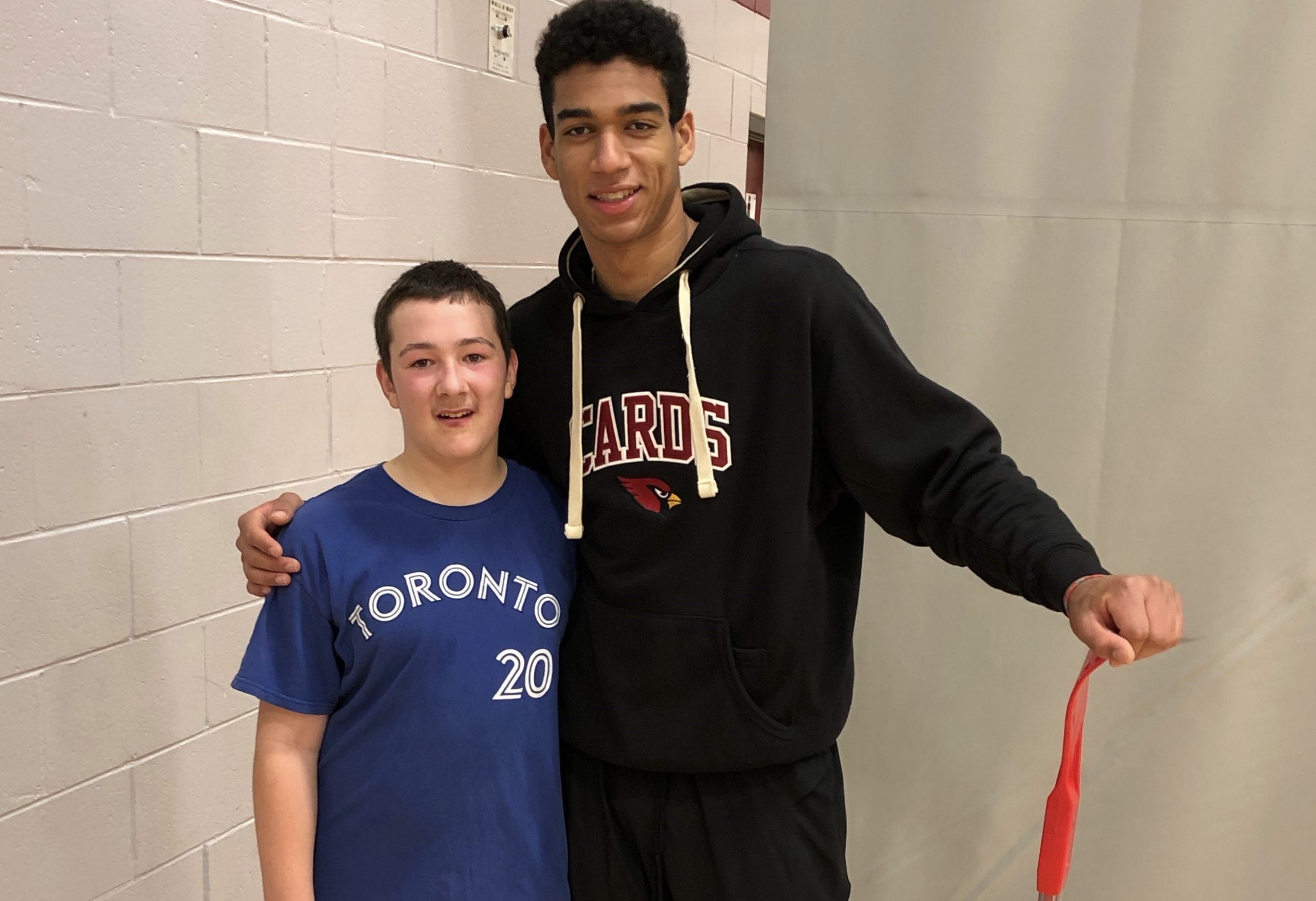 Two boys stand together smiling