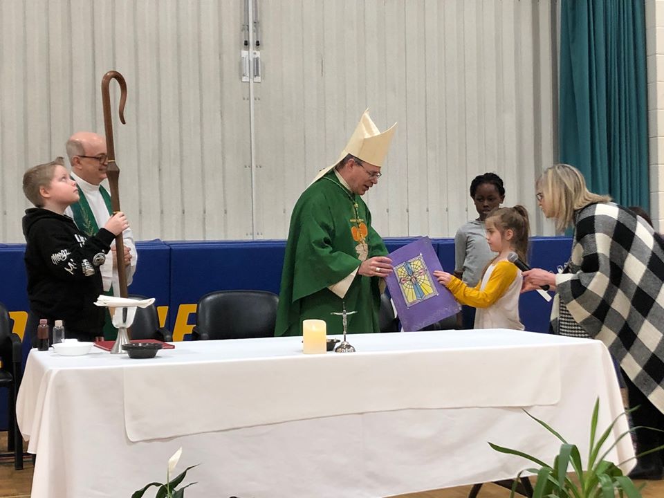 Bishop recieves card from a student.