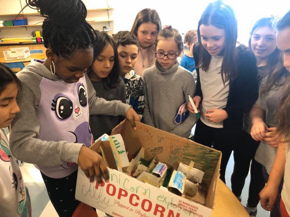 Students Gather around a box.