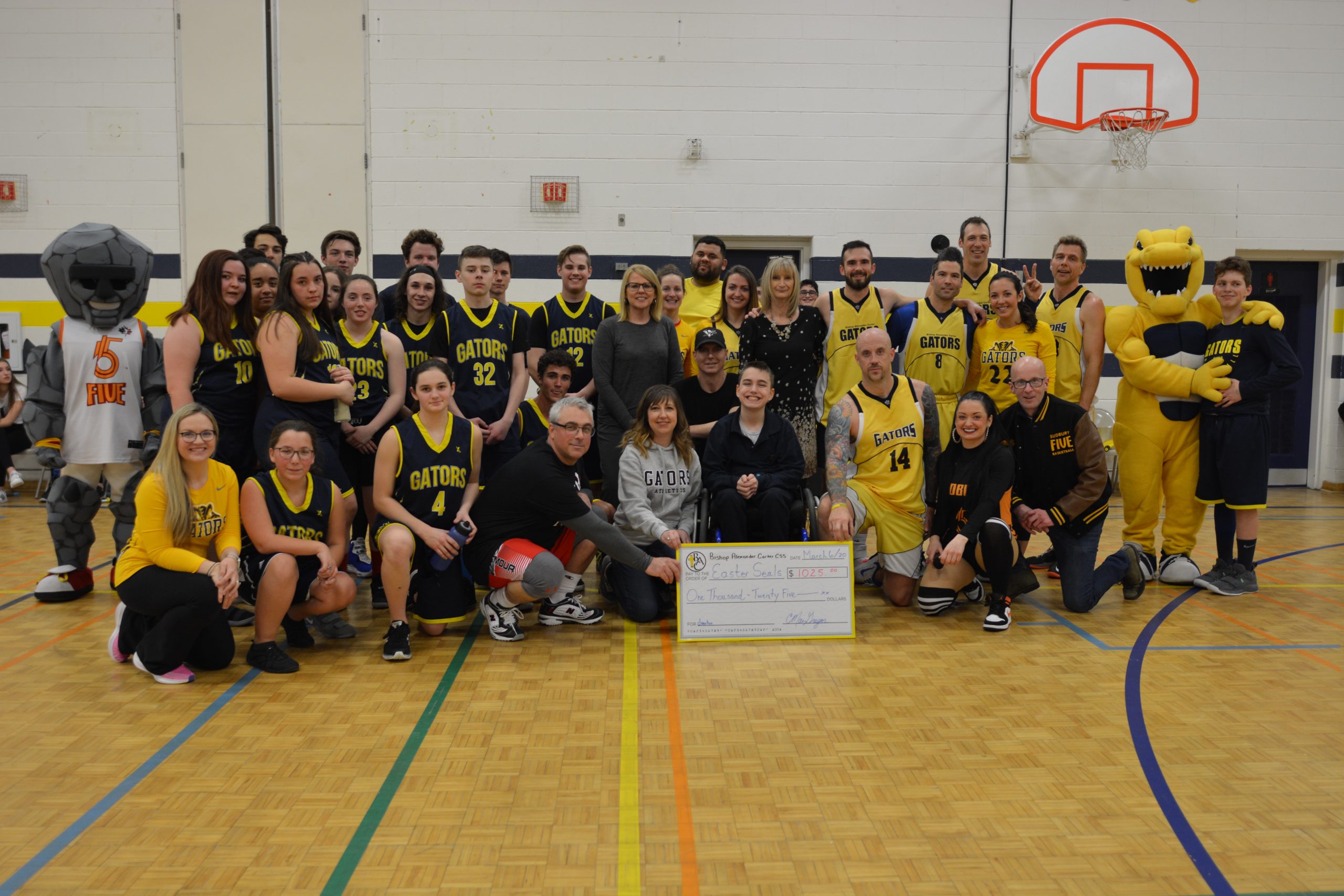 Group stands together with giant cheque