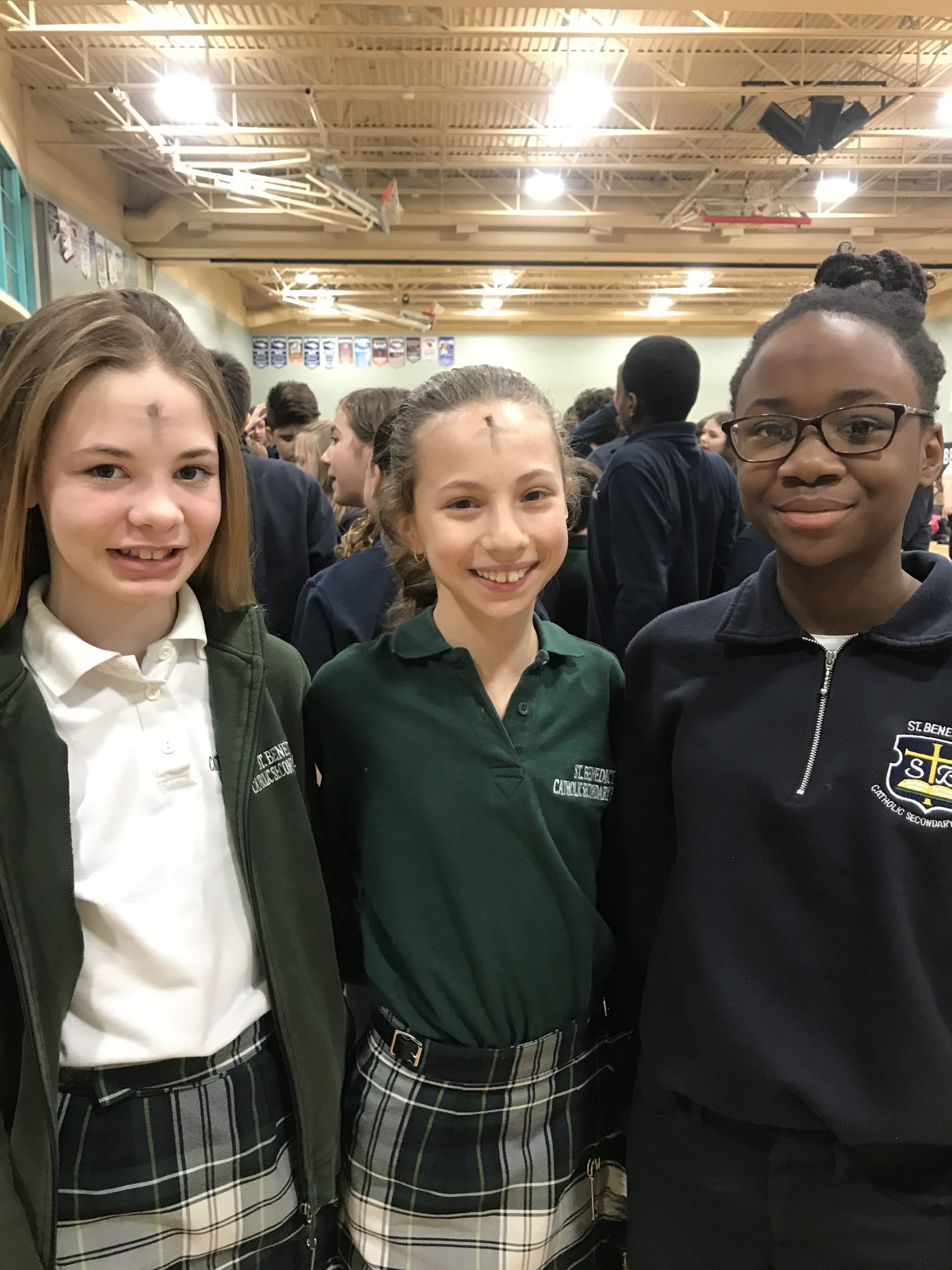 Students mark a cross on their face for ash wednesday.