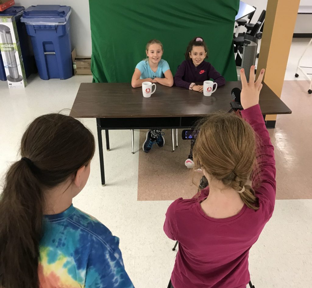 Students work in front of green screen.