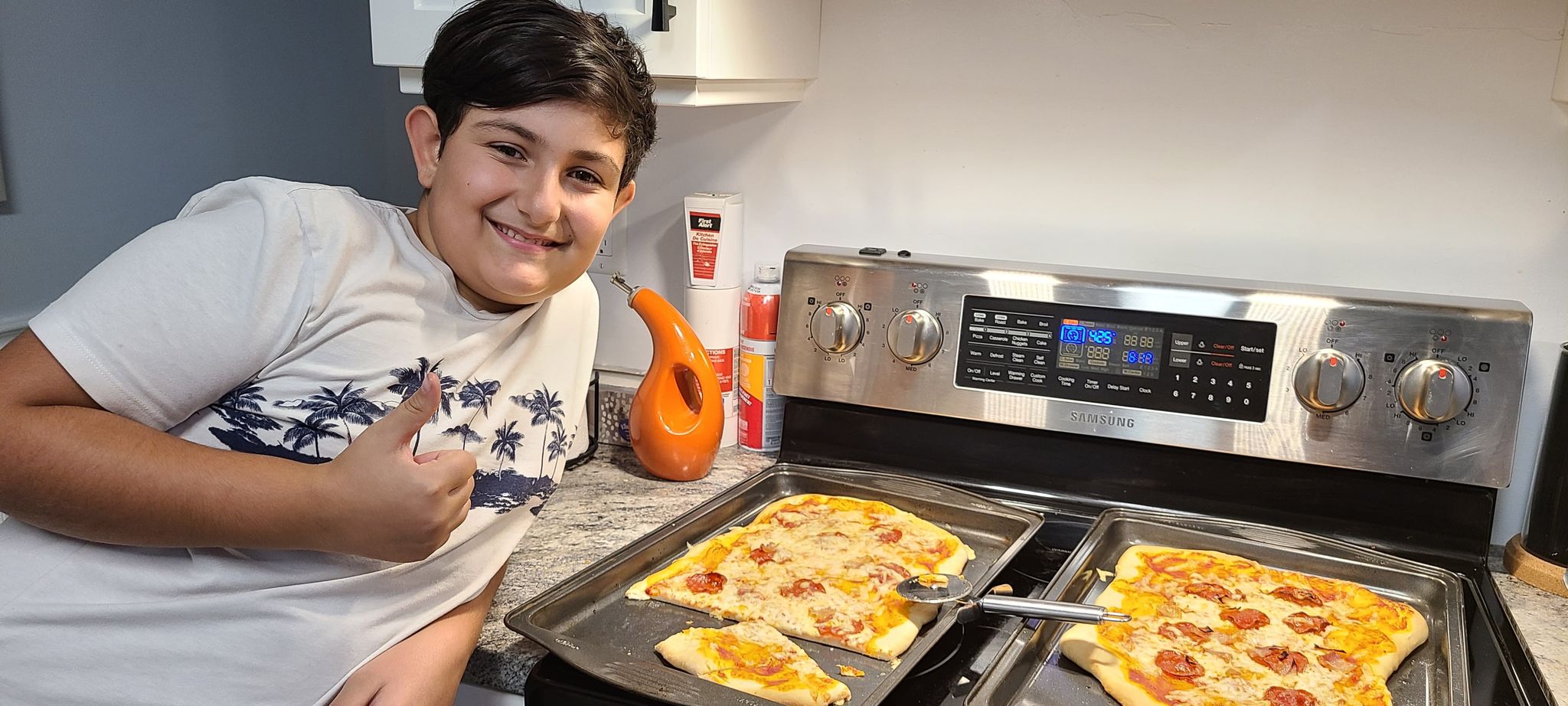 Student smiles with his pizza creation