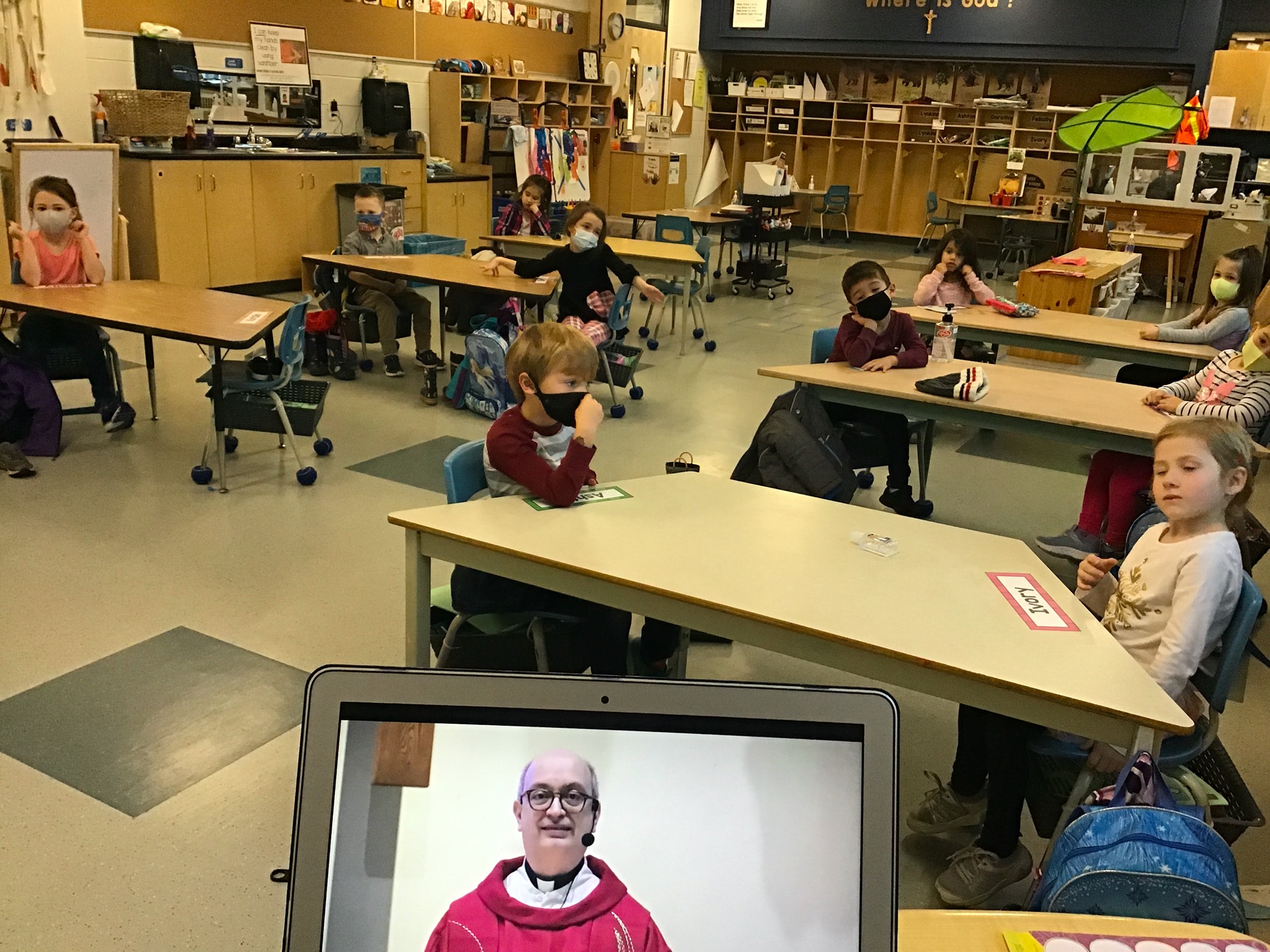 A class oberves a computer screen displaying Father Sam