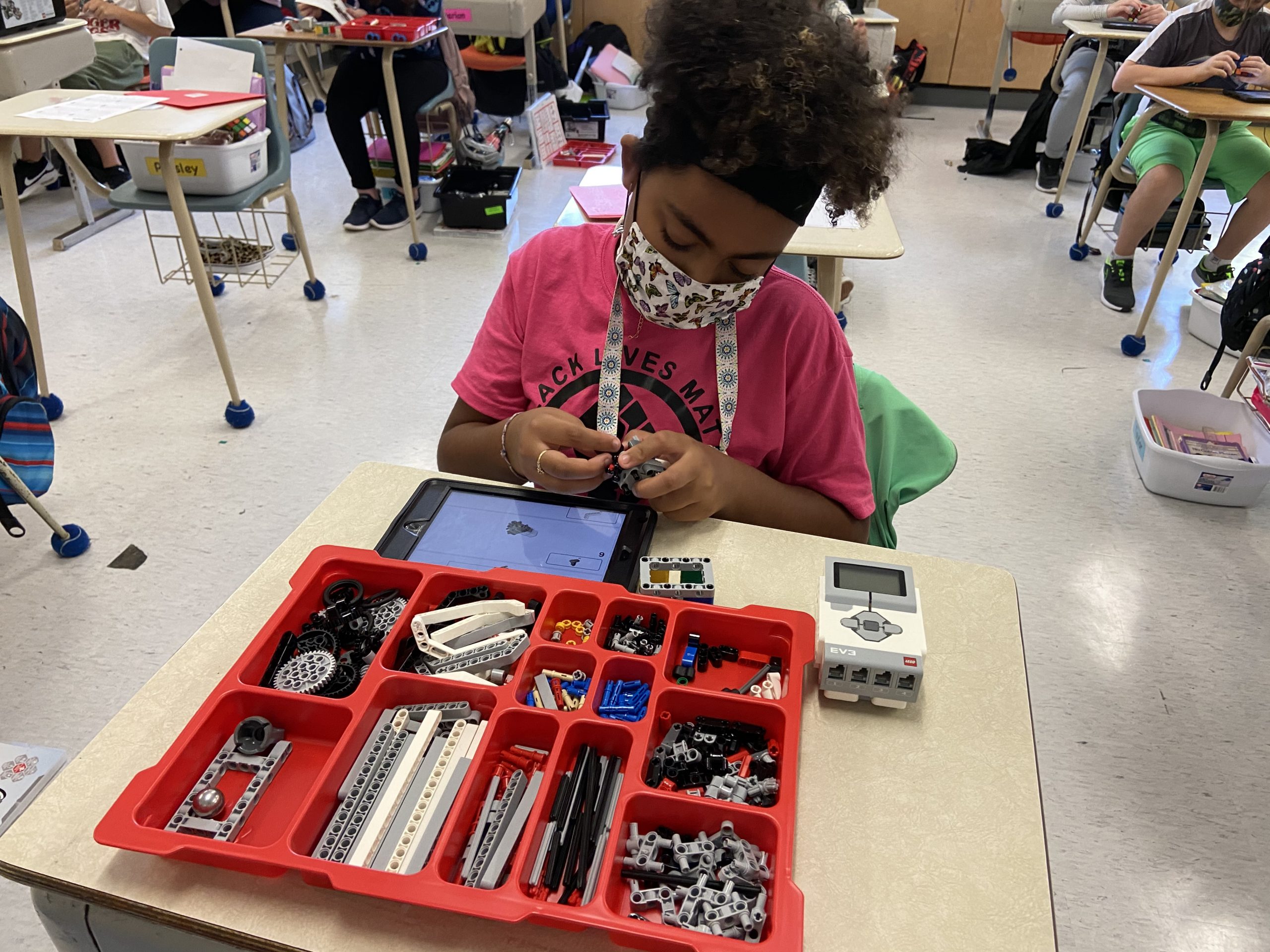 A girl works with her robot kit.