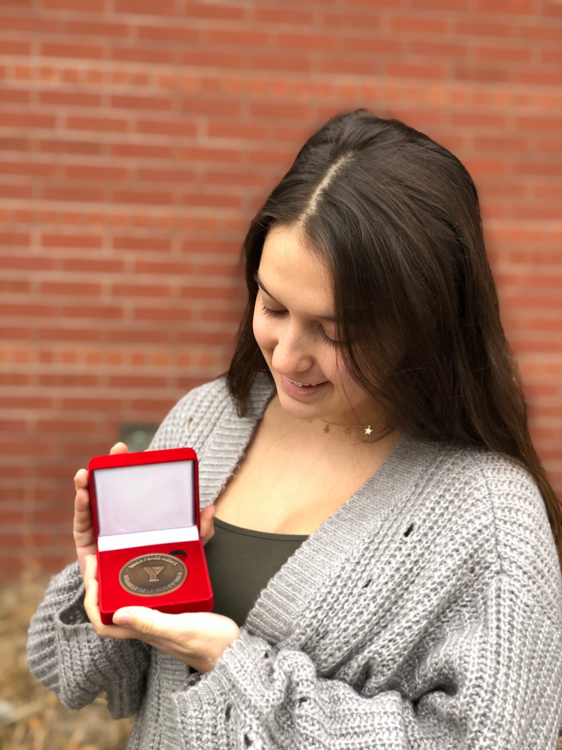 Milena holds the PEACE medal.