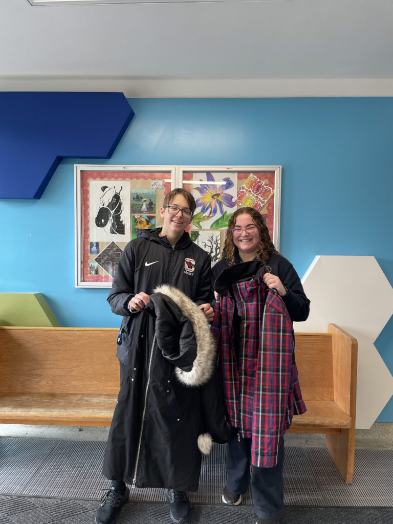Student Trustees hold up coats