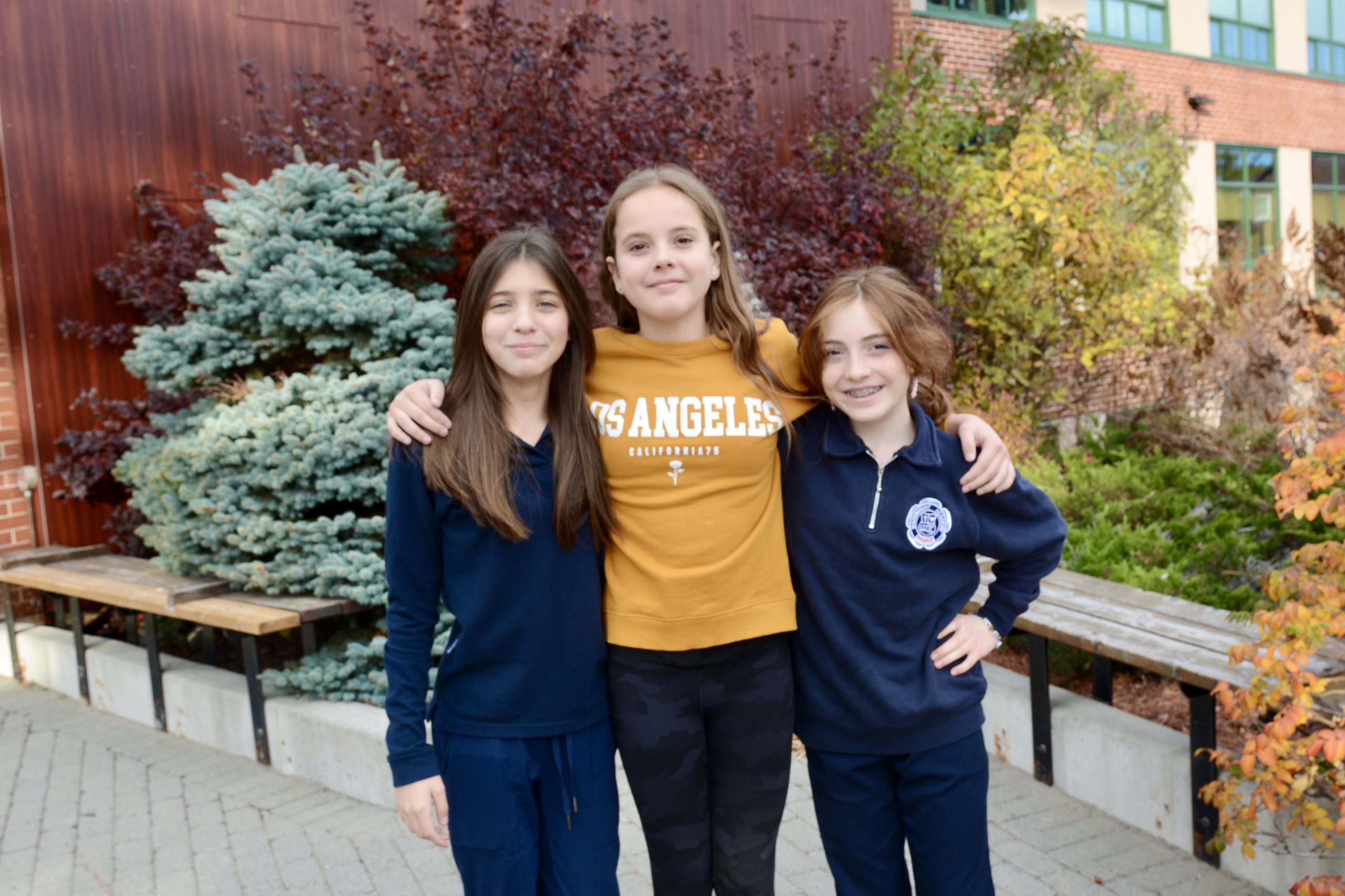 Three students stand together.