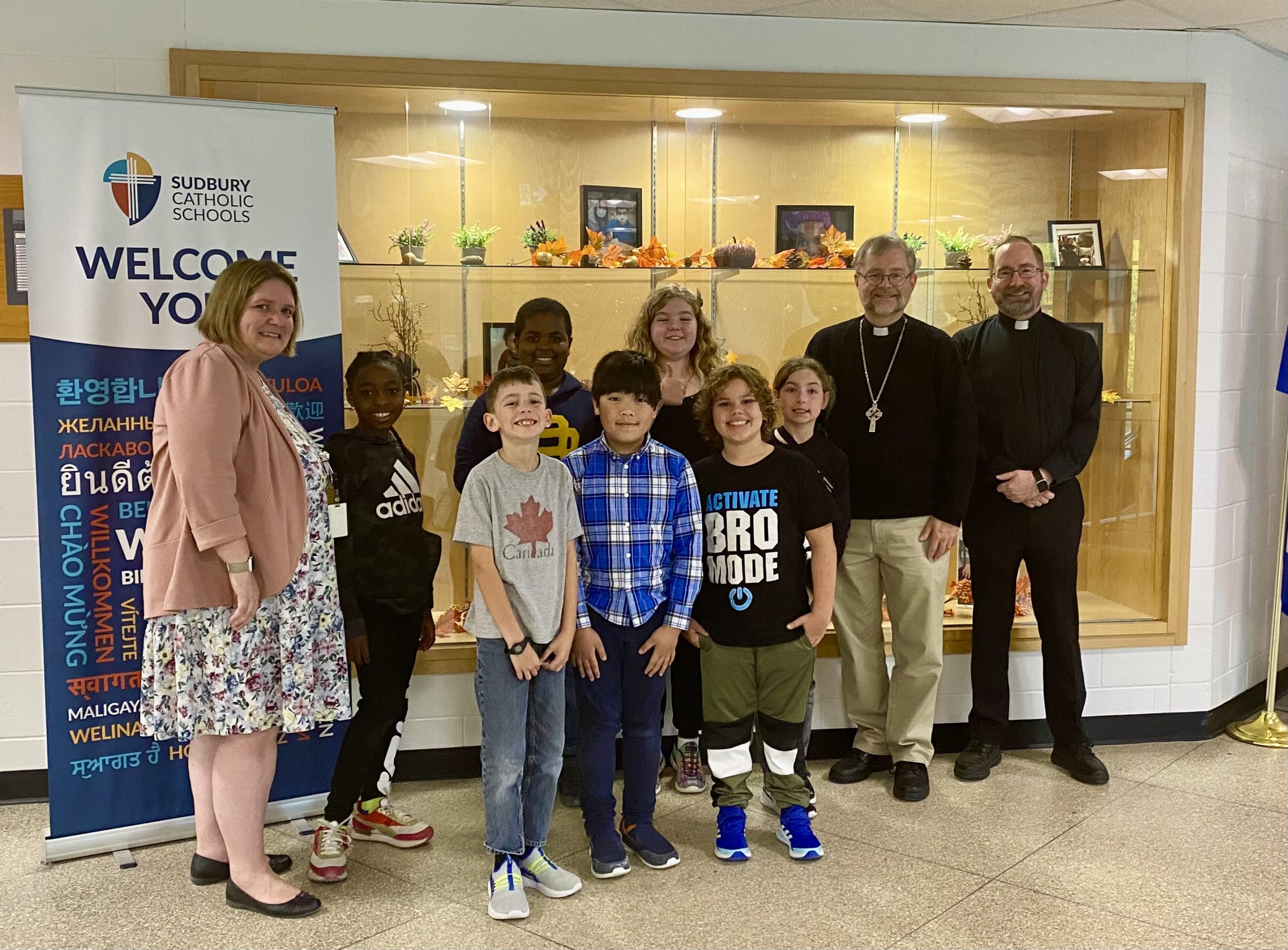 Group of students stand with the Bishop and Father Chad