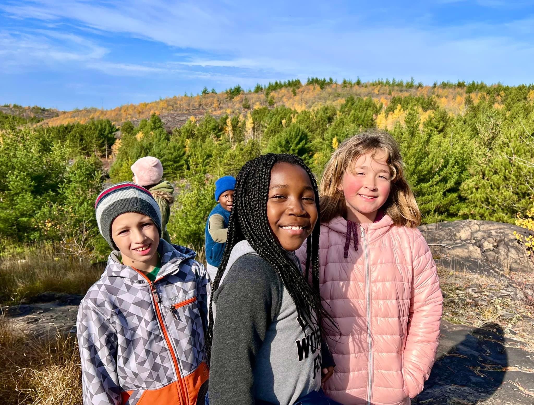 Three Students Stand Together Outside