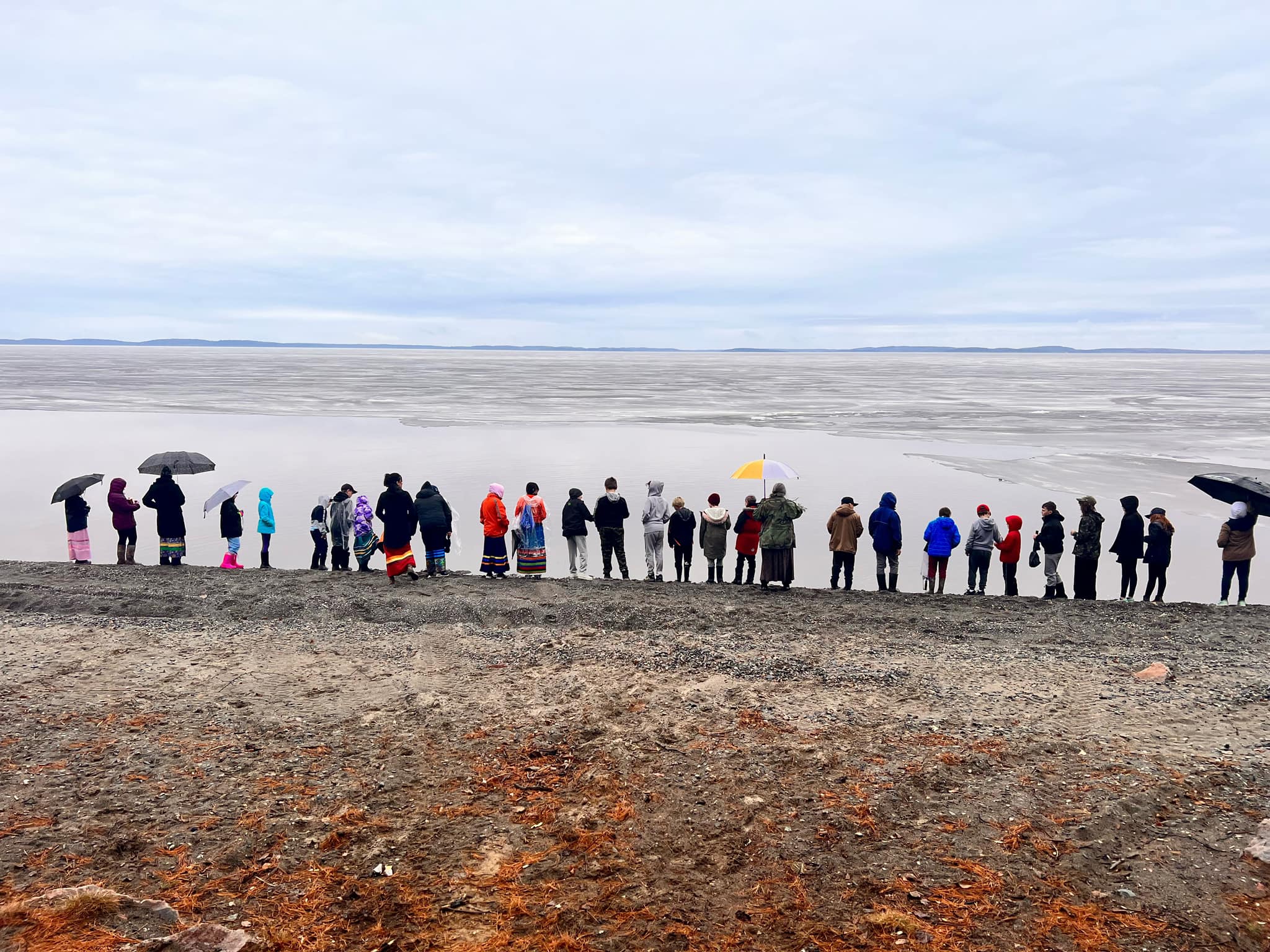 Students stand along the water